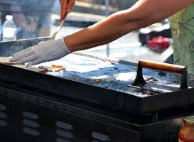 Normal_woman-frying-food-on-a-hot-griddle-at-an-outdoor-f-2022-08-01-04-12-45-utc
